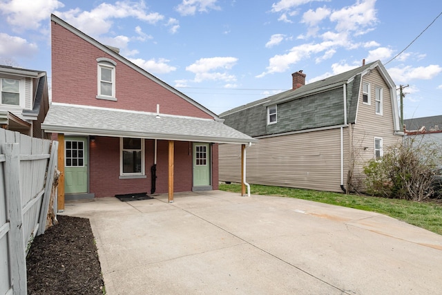 511 Highland Pike, Covington, KY 41014 - rear view of house featuring a shingled roof, fence, a gambrel roof, and brick siding