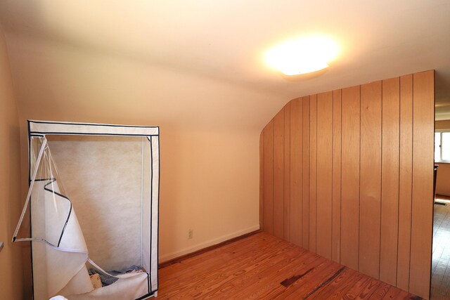 bonus room with vaulted ceiling, wood finished floors, and baseboards