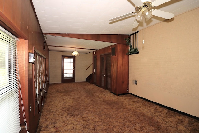 unfurnished room with a ceiling fan, stairs, brick wall, carpet flooring, and visible vents