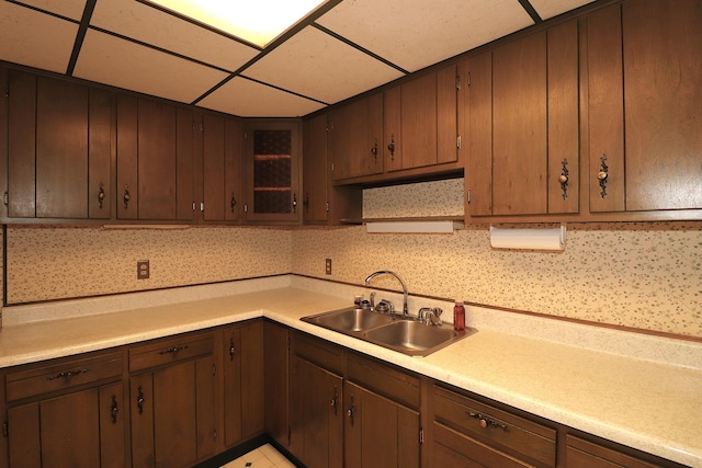 kitchen with light countertops, a sink, and a drop ceiling