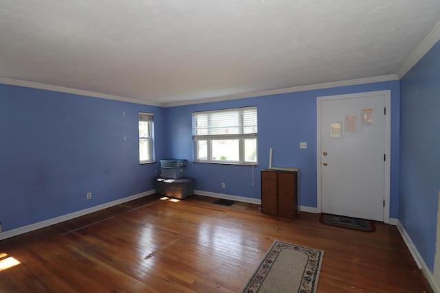 interior space with visible vents, hardwood / wood-style flooring, baseboards, and ornamental molding