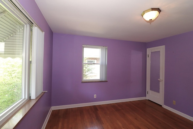 unfurnished room with baseboards and wood finished floors