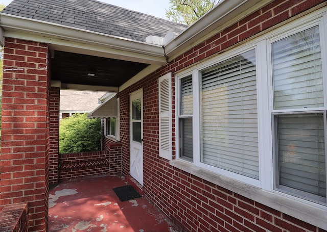 view of side of property with brick siding and a shingled roof