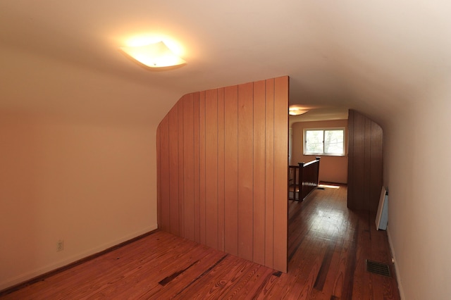bonus room with lofted ceiling, visible vents, baseboard heating, and wood finished floors