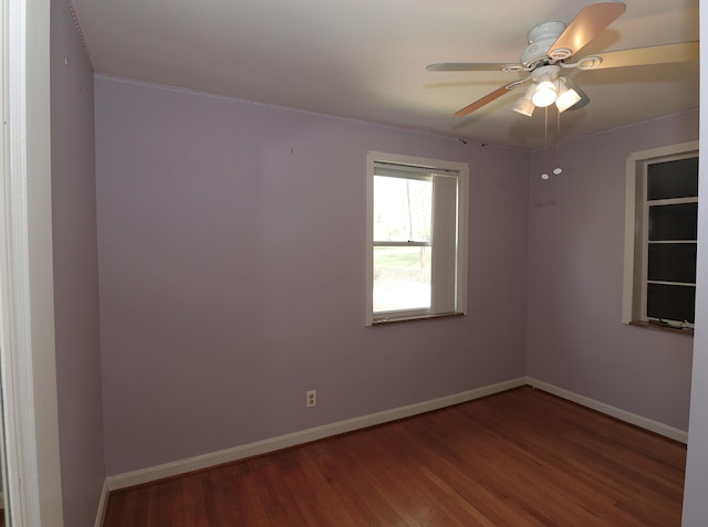 spare room featuring wood finished floors, baseboards, and ceiling fan