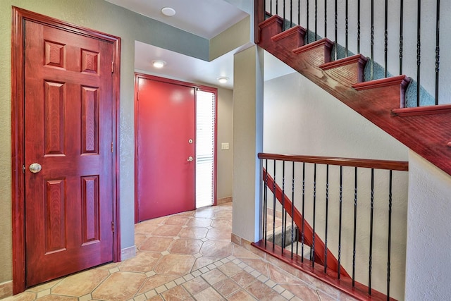 entrance foyer featuring a textured wall and tile patterned flooring
