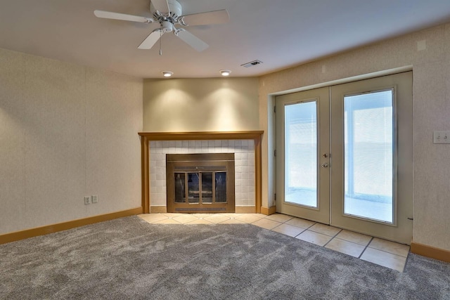unfurnished living room featuring tile patterned floors, french doors, carpet flooring, visible vents, and ceiling fan