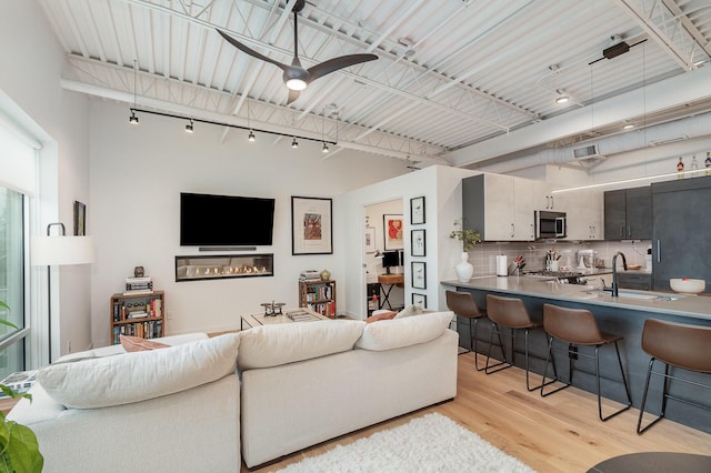 living area featuring visible vents, light wood-type flooring, and ceiling fan