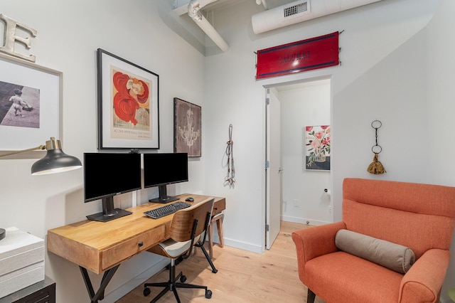 office featuring light wood-style floors, baseboards, and visible vents