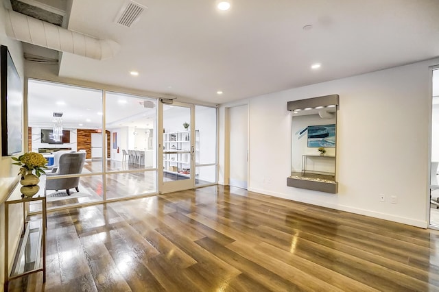 unfurnished living room featuring recessed lighting, visible vents, baseboards, and wood finished floors