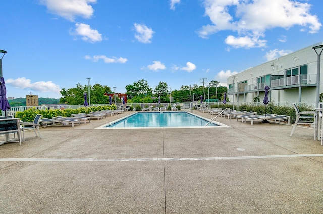 community pool with a patio and fence