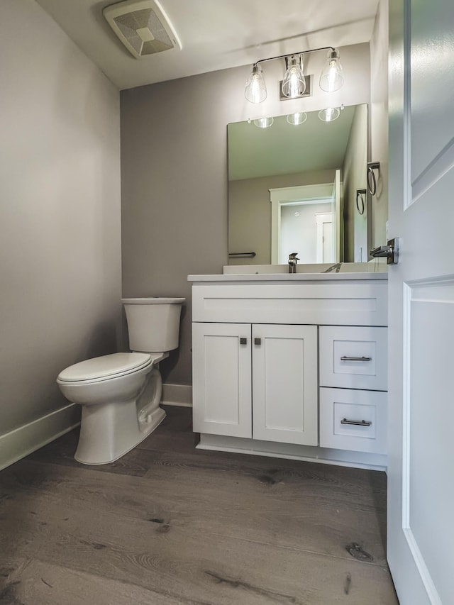 739 Manhattan Blvd Unit 103, Dayton, KY 41074 - bathroom featuring visible vents, baseboards, toilet, vanity, and wood finished floors