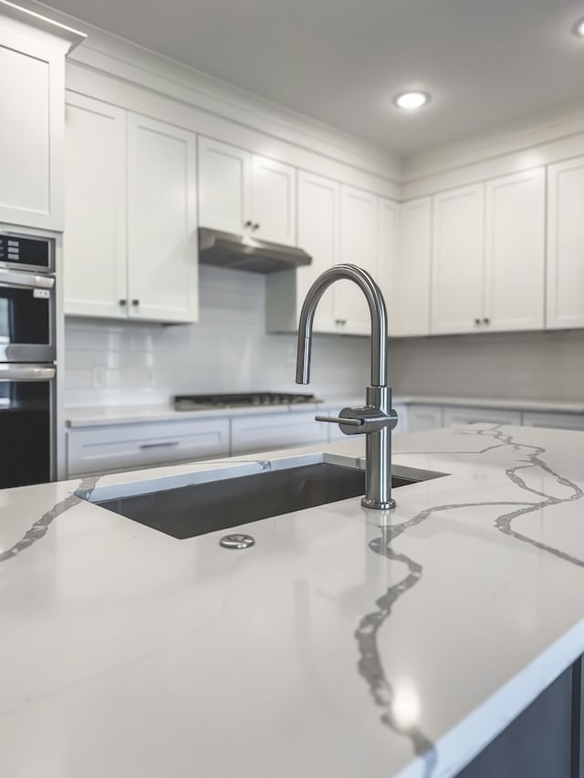 739 Manhattan Blvd Unit 103, Dayton, KY 41074 - kitchen featuring recessed lighting, white cabinets, under cabinet range hood, light stone countertops, and stainless steel double oven