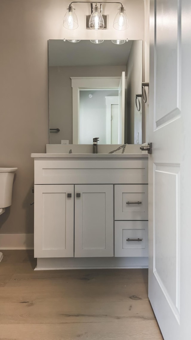 739 Manhattan Blvd Unit 103, Dayton, KY 41074 - half bathroom featuring toilet, wood finished floors, vanity, and baseboards