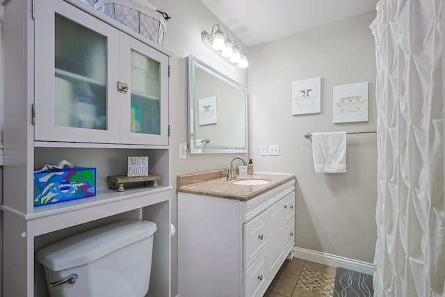full bathroom featuring toilet, tile patterned floors, vanity, and baseboards