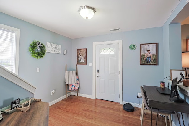 foyer entrance featuring light wood-style floors, baseboards, and visible vents