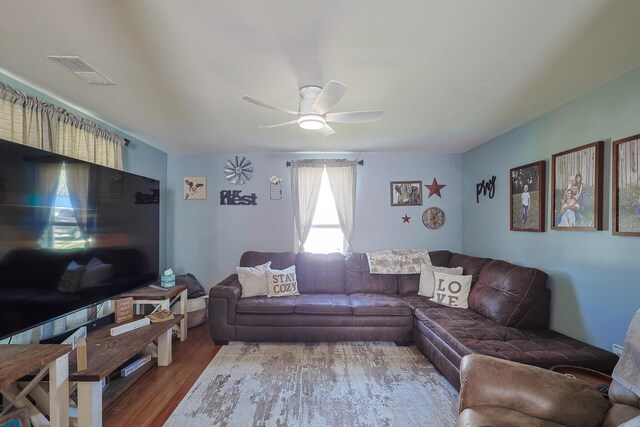 living room with visible vents, a ceiling fan, and wood finished floors