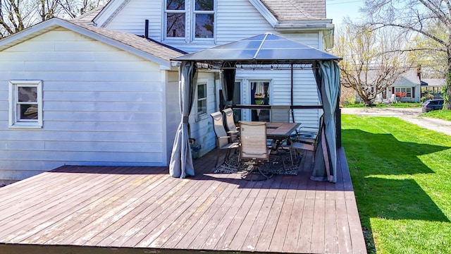 wooden terrace featuring a gazebo, a yard, and outdoor dining area