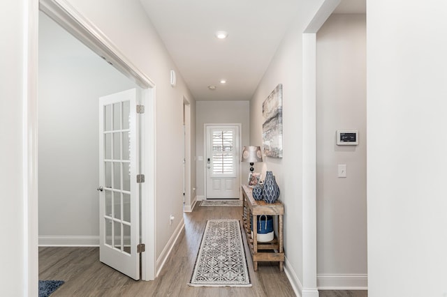 doorway with wood finished floors, baseboards, and recessed lighting