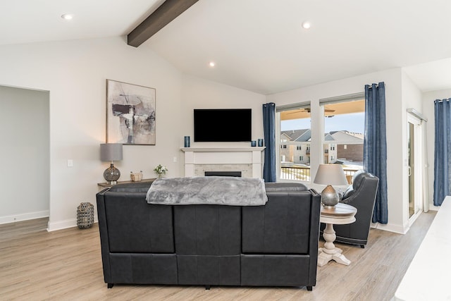 living room featuring light wood-style floors, baseboards, a fireplace, and recessed lighting