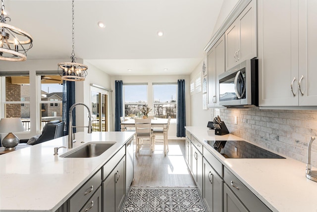 kitchen with appliances with stainless steel finishes, a chandelier, a sink, gray cabinetry, and recessed lighting