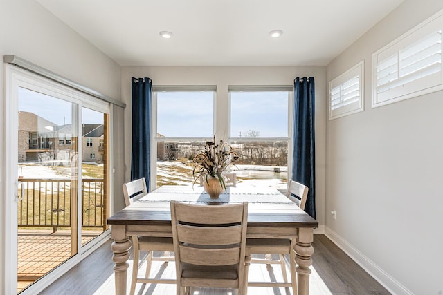 dining room with dark wood-type flooring, healthy amount of natural light, baseboards, and recessed lighting