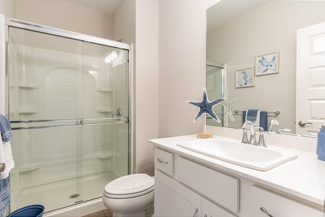 bathroom featuring toilet, a stall shower, and vanity