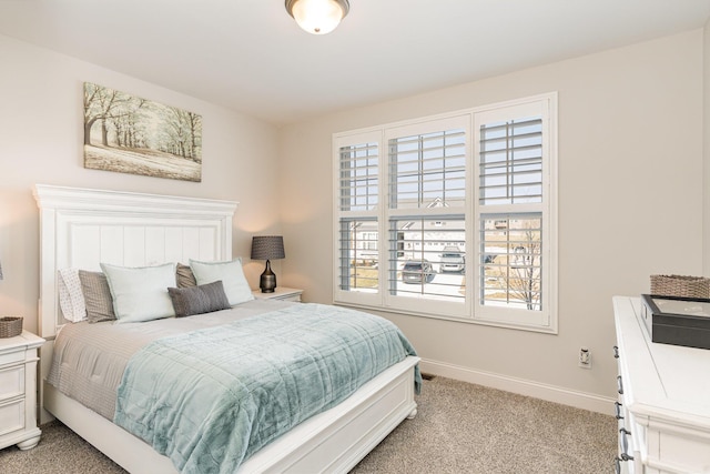 bedroom featuring light colored carpet and baseboards