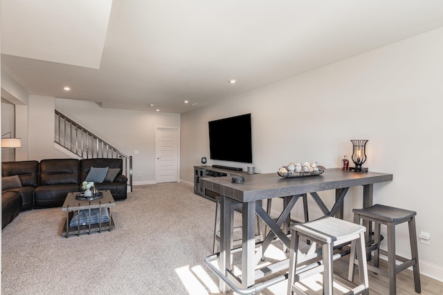 living area featuring stairway, baseboards, recessed lighting, and light colored carpet