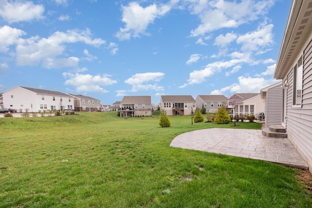 view of yard with a residential view and a patio