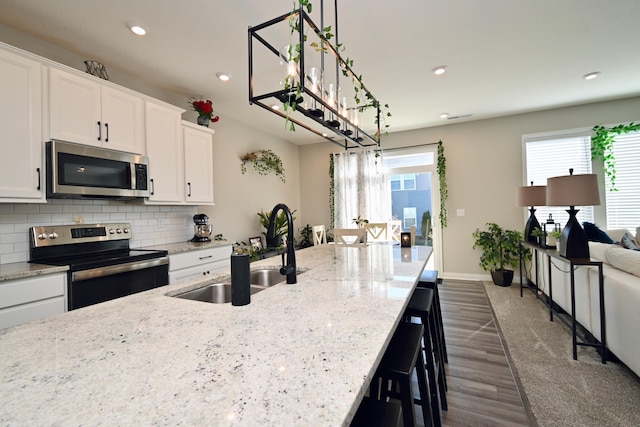 kitchen featuring a sink, appliances with stainless steel finishes, recessed lighting, white cabinetry, and backsplash