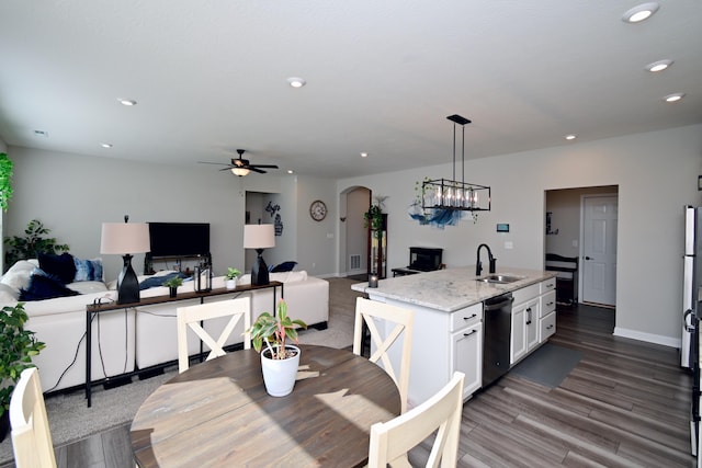 dining space with baseboards, recessed lighting, dark wood-type flooring, arched walkways, and ceiling fan with notable chandelier