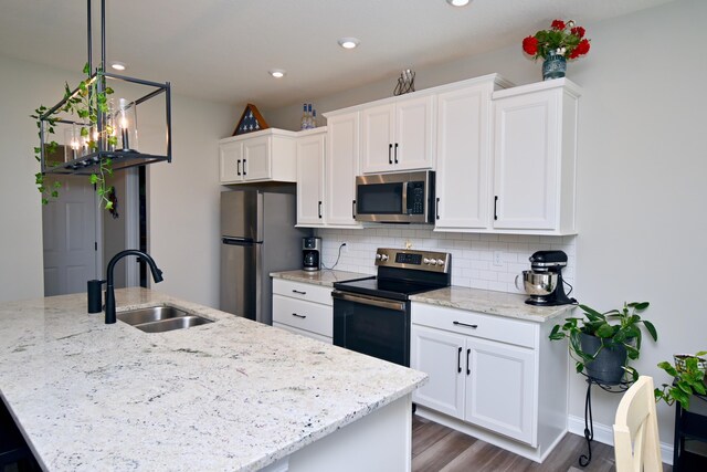 kitchen featuring a sink, backsplash, white cabinets, and stainless steel appliances
