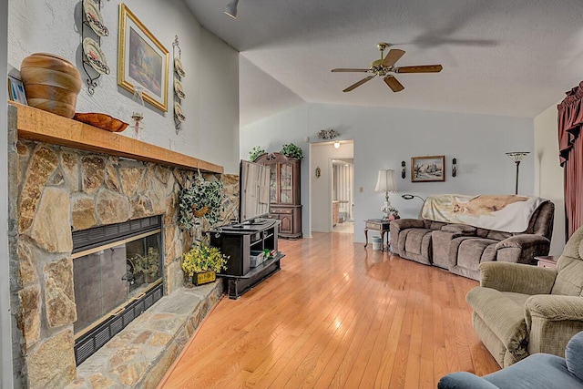13471 Peach Grove Rd, California, KY 41007 - living area with lofted ceiling, light wood-style floors, a stone fireplace, and ceiling fan