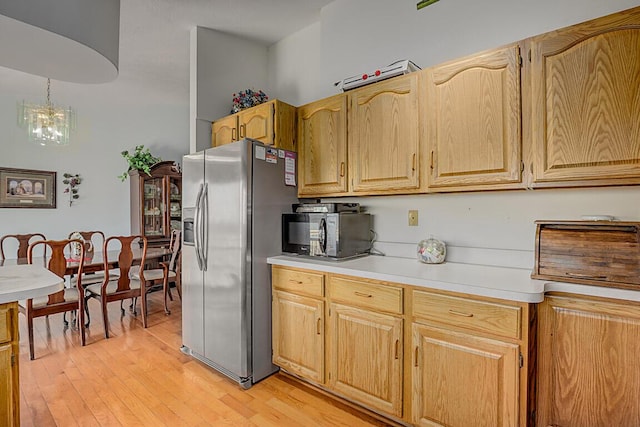13471 Peach Grove Rd, California, KY 41007 - kitchen featuring light wood-style flooring, light countertops, stainless steel refrigerator with ice dispenser, and a chandelier
