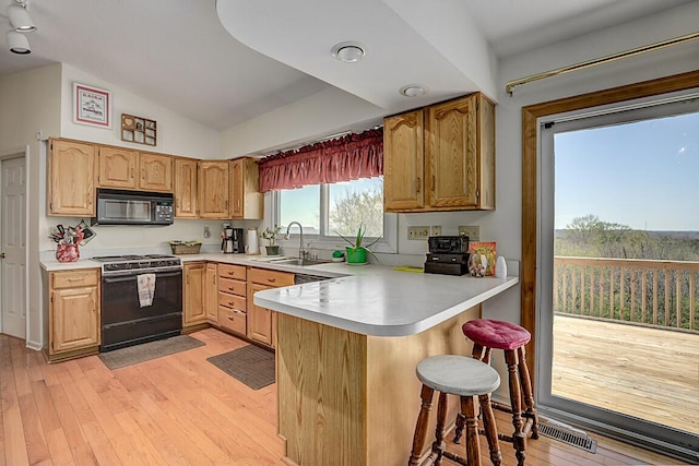 13471 Peach Grove Rd, California, KY 41007 - kitchen with light countertops, a kitchen bar, a peninsula, black appliances, and lofted ceiling