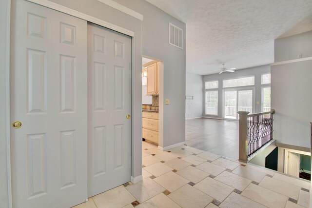 2141 Tantallon Dr, Fort Mitchell, KY 41017 - hall featuring a textured ceiling, visible vents, baseboards, and an upstairs landing