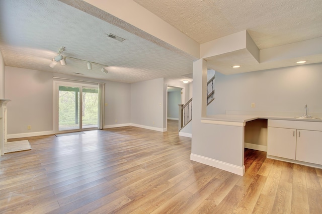 2141 Tantallon Dr, Fort Mitchell, KY 41017 - unfurnished living room with light wood-style floors, stairs, a textured ceiling, and visible vents