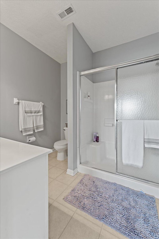bathroom with tile patterned floors, a stall shower, toilet, and visible vents