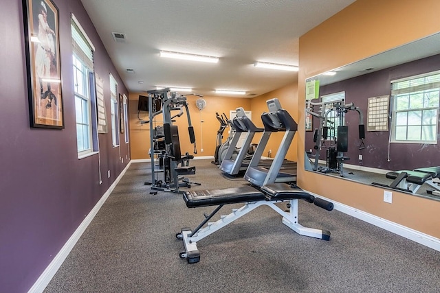 exercise room with visible vents and baseboards