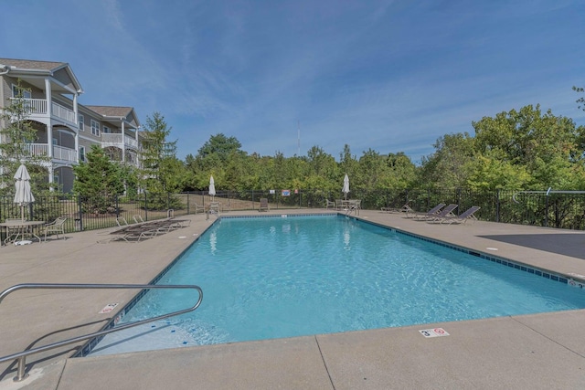 community pool with fence and a patio area