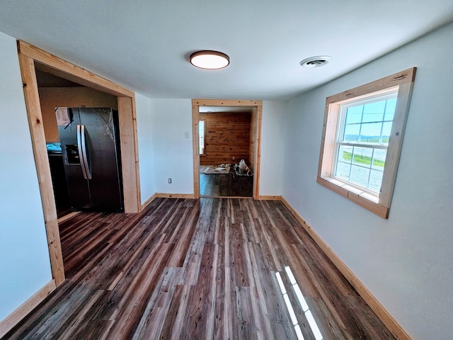 interior space featuring visible vents, dark wood-style flooring, and baseboards