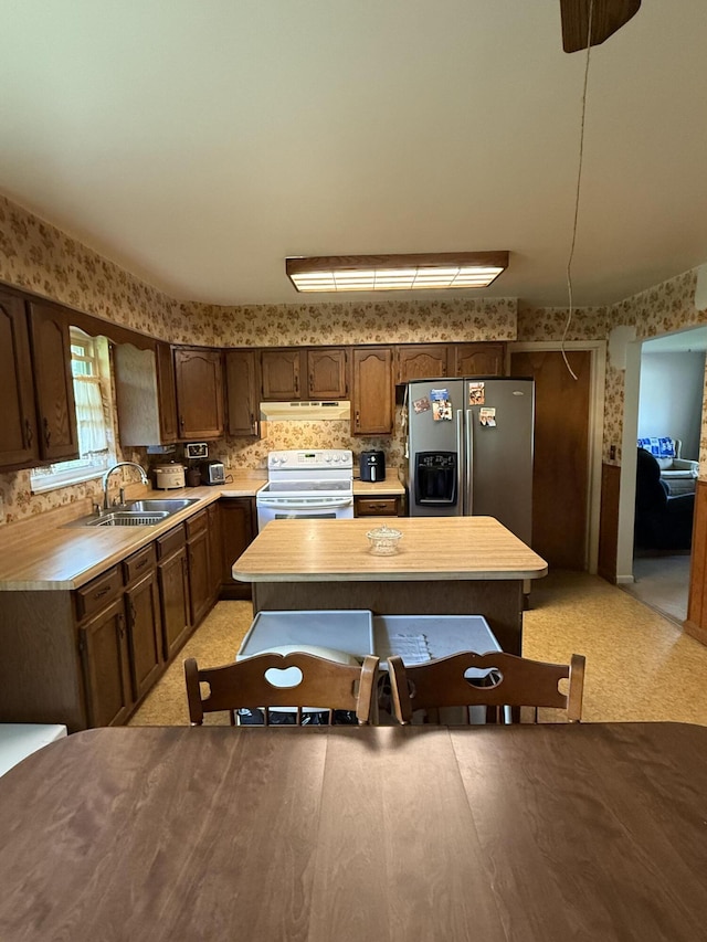 143 Capri Dr, Fort Thomas, KY 41075 - kitchen with white electric range, stainless steel fridge with ice dispenser, under cabinet range hood, wallpapered walls, and a sink