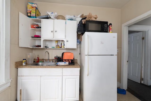 1706 Eastern Ave, Covington, KY 41014 - kitchen featuring freestanding refrigerator, black microwave, a sink, open shelves, and white cabinets