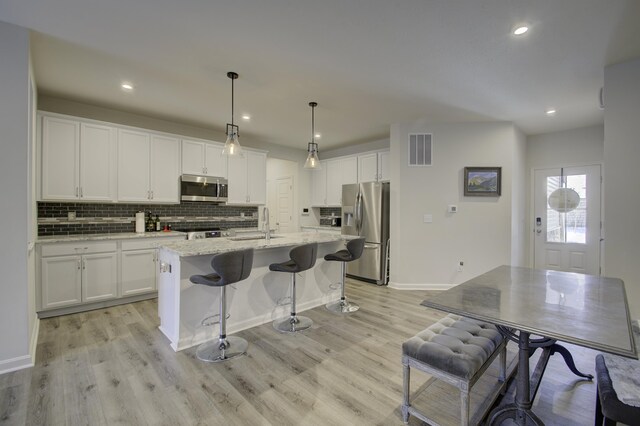 714 Streamside Dr Unit L, Alexandria, KY 41001 - kitchen featuring a sink, white cabinets, tasteful backsplash, and stainless steel appliances