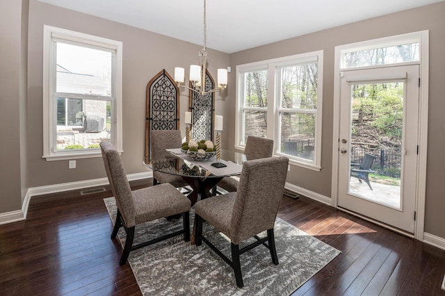 dining room with a chandelier, dark wood-style flooring, baseboards, and a wealth of natural light