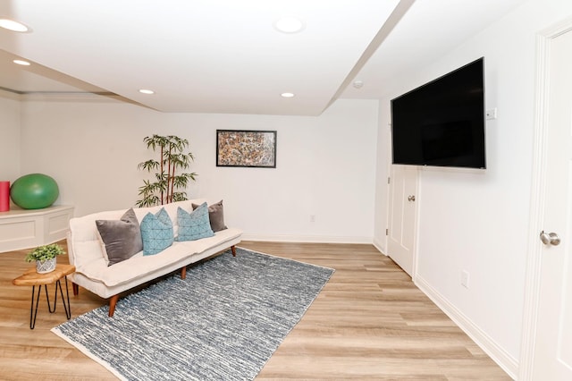 living area with baseboards, light wood-type flooring, and recessed lighting