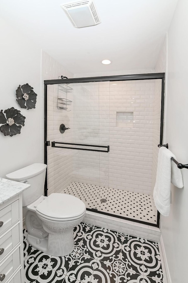 bathroom with toilet, tile patterned floors, visible vents, and a stall shower