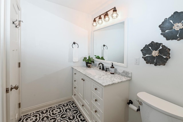 bathroom featuring vanity, baseboards, and toilet