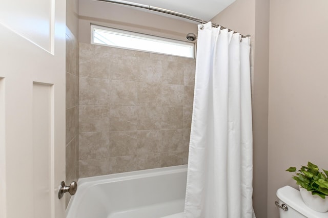 bathroom with toilet and shower / bath combo with shower curtain
